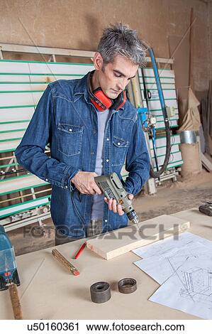 Stock Image - Man working with a drill. Fotosearch