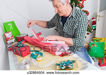 Man wrapping gifts View Large Photo Image Picture - Man wrapping gifts. Fotosearch