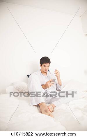 Stock Image - Man writing by phone. Fotosearch