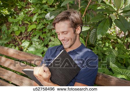 Man writing in the park View Large Photo Image Stock Photograph - Man writing in the park. Fotosearch