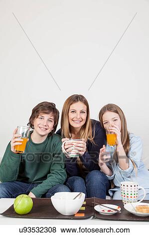 Mom with your two sons drinking juice in the breakfast View Large Photo Image Stock Photo - Mom with your two sons drinking juice in the breakfast. Fotosearch
