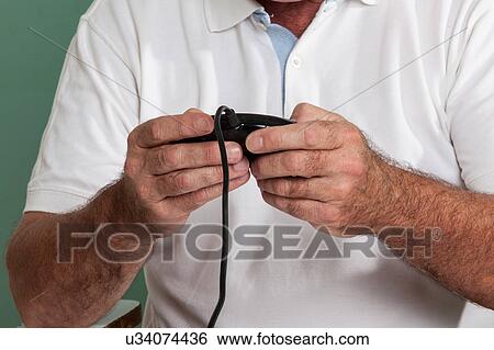 Stock Photograph - Old man playing videogames. Fotosearch