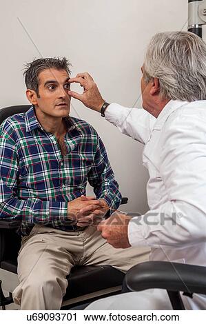 Stock Image - Ophthalmologist checking the eyes. Fotosearch