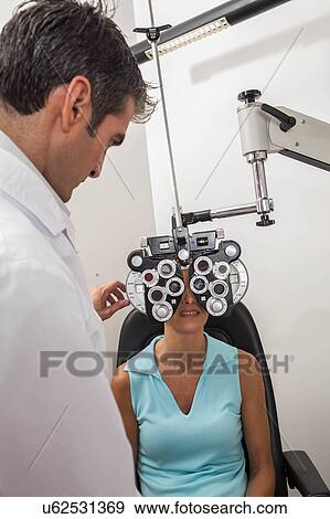 Stock Photo - Ophthalmologist checking the eyes. Fotosearch