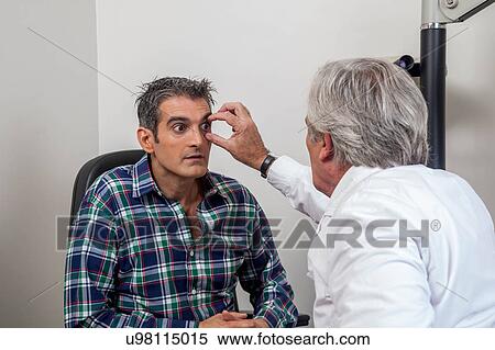 Ophthalmologist checking the eyes View Large Photo Image Stock Photography - Ophthalmologist checking the eyes. Fotosearch