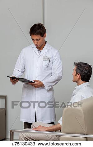 Stock Image - Ophthalmologist looking at chart. Fotosearch