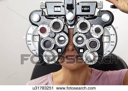 Stock Image - Ophthalmologist performing eye tests. Fotosearch