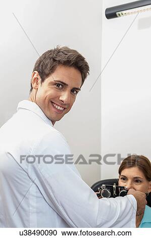 Stock Image - Ophthalmologist putting special lenses. Fotosearch