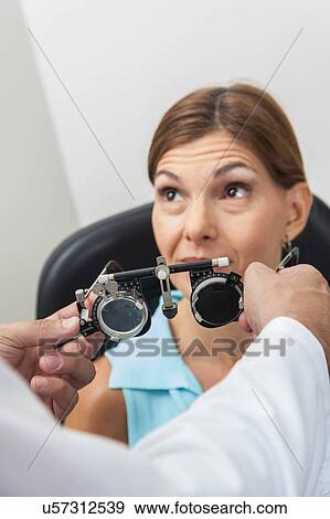Stock Photo - Ophthalmologist putting special lenses. Fotosearch