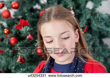Stock Image - Peaceful girl in front of the tree christmas. Fotosearch