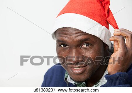 Stock Photo - Portrait of man with Christmas hat. Fotosearch