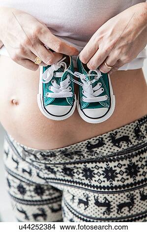 Pregnant belly with slippers View Large Photo Image Picture - Pregnant belly with slippers. Fotosearch