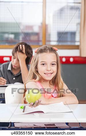 Stock Image - pretty girl giving a apple. Fotosearch