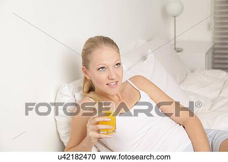 Stock Image - Pretty woman drinking a juice. Fotosearch