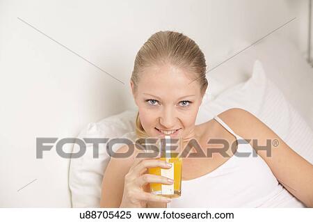 Stock Photography - Pretty woman drinking a juice. Fotosearch
