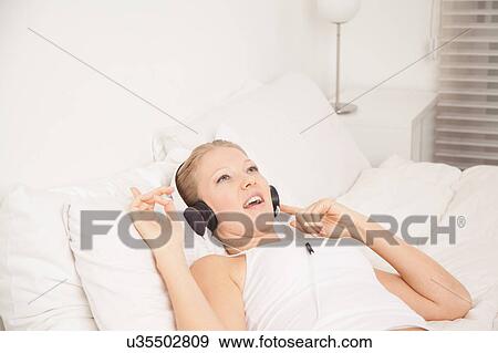 Stock Photo - Pretty woman listening to music. Fotosearch