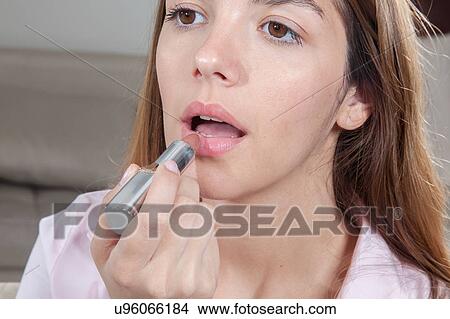 Pretty woman putting her lipstick View Large Photo Image Picture - Pretty woman putting her lipstick. Fotosearch