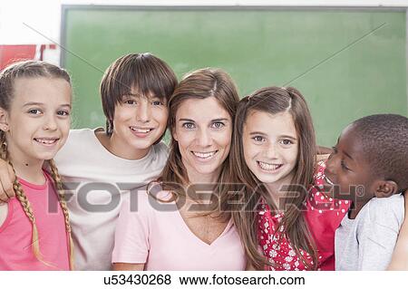 Stock Photo - Pupils and teacher looking at camera. Fotosearch