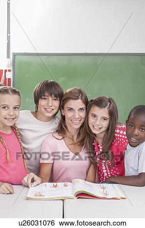 Stock Photograph - Pupils and teacher looking at camera. Fotosearch