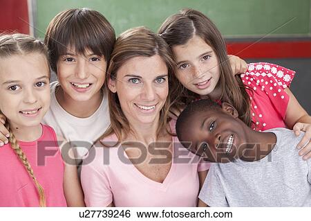 Stock Photograph - Pupils and teacher looking at camera and smiling. Fotosearch