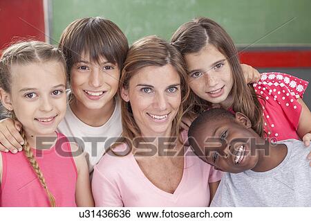 Stock Photograph - Pupils and teacher looking at camera and smiling. Fotosearch