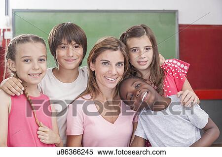 Stock Photography - Pupils and teacher looking at camera and smiling. Fotosearch