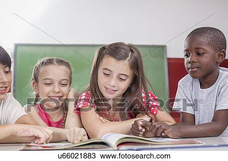 Stock Image - Pupils reading a book. Fotosearch