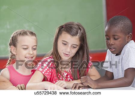 Pupils reading a book View Large Photo Image Stock Photo - Pupils reading a book. Fotosearch