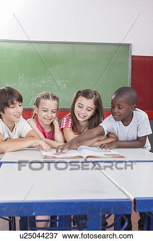Stock Photo - Pupils reading togethers. Fotosearch