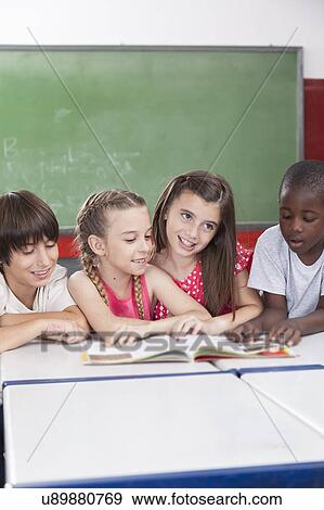 Stock Photo - Pupils reading togethers. Fotosearch