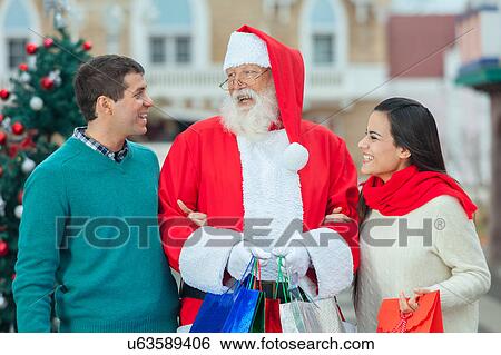 santa claus with a young couple View Large Photo Image Stock Photograph - santa claus with a young couple. Fotosearch