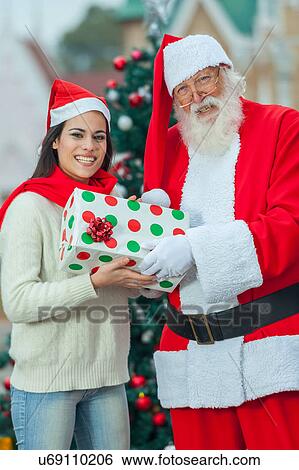 santa giving a gift to a young woman View Large Photo Image Stock Photograph - santa giving a gift to a young woman. Fotosearch