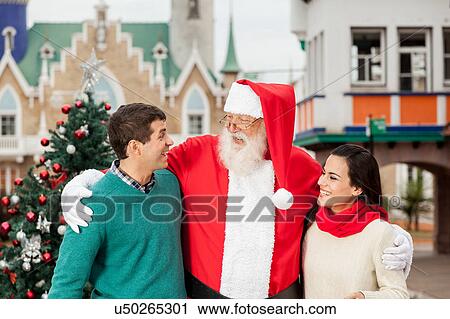 Stock Image - santa with a young couple. Fotosearch