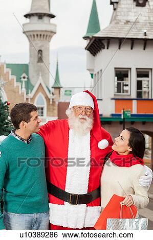 Santa with a young couple View Large Photo Image Stock Photograph - Santa with a young couple. Fotosearch