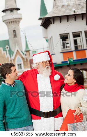 Santa with a young couple View Large Photo Image Stock Photography - Santa with a young couple. Fotosearch