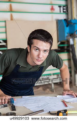 Stock Image - Serious capenter in his desk. Fotosearch