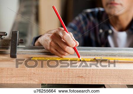 Serious carpenter marking a plank View Large Photo Image Picture - Serious carpenter marking a plank. Fotosearch