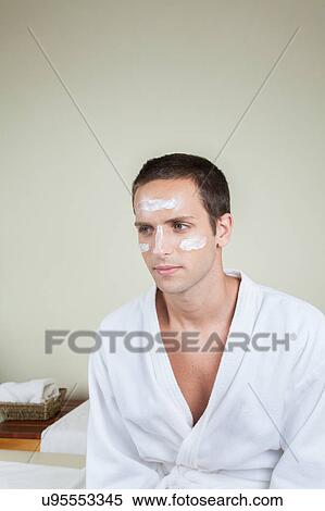 Stock Photography - Serious guy with cream on her face. Fotosearch