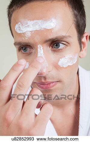 Serious man applying face cream View Large Photo Image Stock Image - Serious man applying face cream. Fotosearch