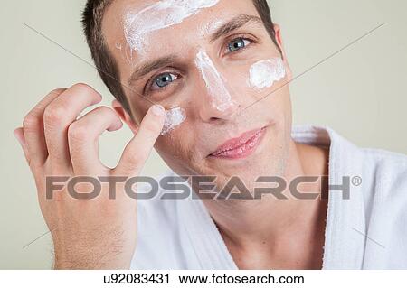 Serious man putting face cream with your finger View Large Photo Image Stock Image - Serious man putting face cream with your finger. Fotosearch