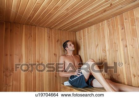 Picture - Serious man sit inside the sauna. Fotosearch