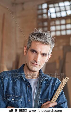 Stock Image - Serious man wholding a ruler. Fotosearch