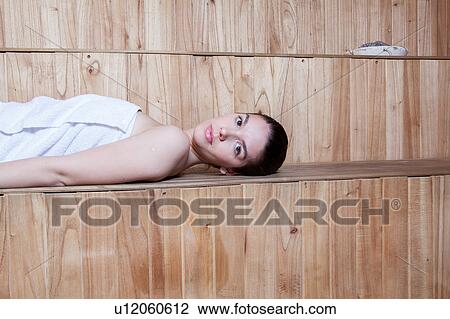Serious woman lying inside the sauna View Large Photo Image Stock Image - Serious woman lying inside the sauna. Fotosearch