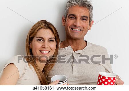 Stock Image - Smiling couple drinking a coffee. Fotosearch