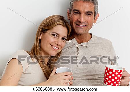Smiling couple drinking a coffee View Large Photo Image Stock Photography - Smiling couple drinking a coffee. Fotosearch