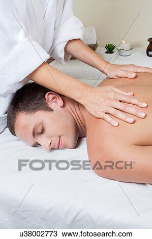 Stock Image - Smiling man gets a massage. Fotosearch