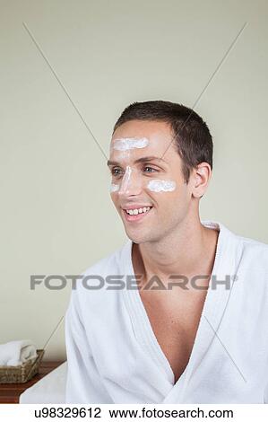 Stock Image - Smiling man with cream on her face. Fotosearch
