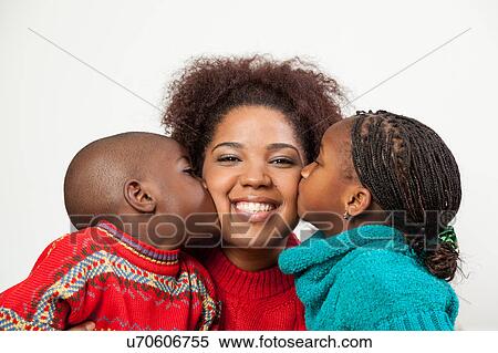 Stock Photography - Son and daughter kissing her mother. Fotosearch