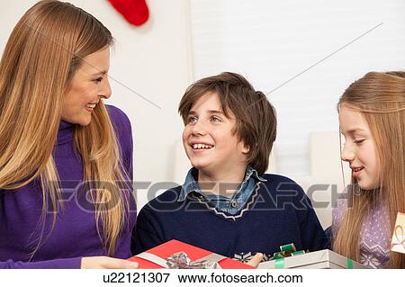 Son giving to his mother a gift for christmas View Large Photo Image Stock Photo - Son giving to his mother a gift for christmas. Fotosearch