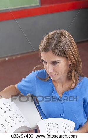Stock Image - Teacher giving the exam. Fotosearch